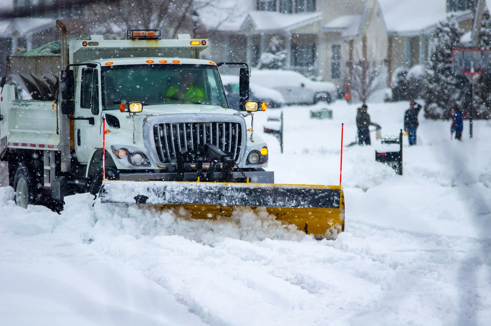 Snow plow clearing a road during a winter storm