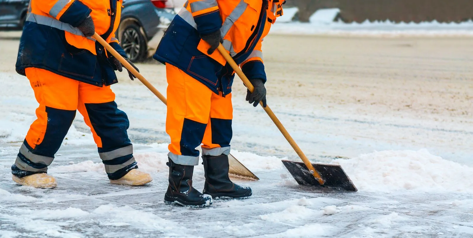 Snow removal crew shoveling an icy walkway